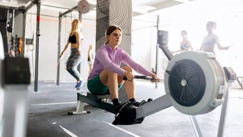 movement exercise: woman using rowing machine 1497022318