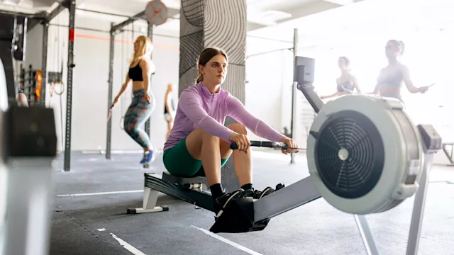 movement exercise: woman using rowing machine 1497022318