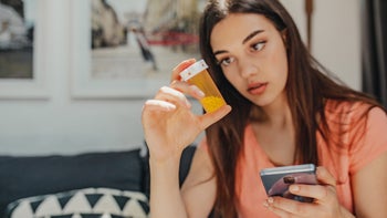 Lithium: Alcohol: holding pill bottle and phone 1287314997