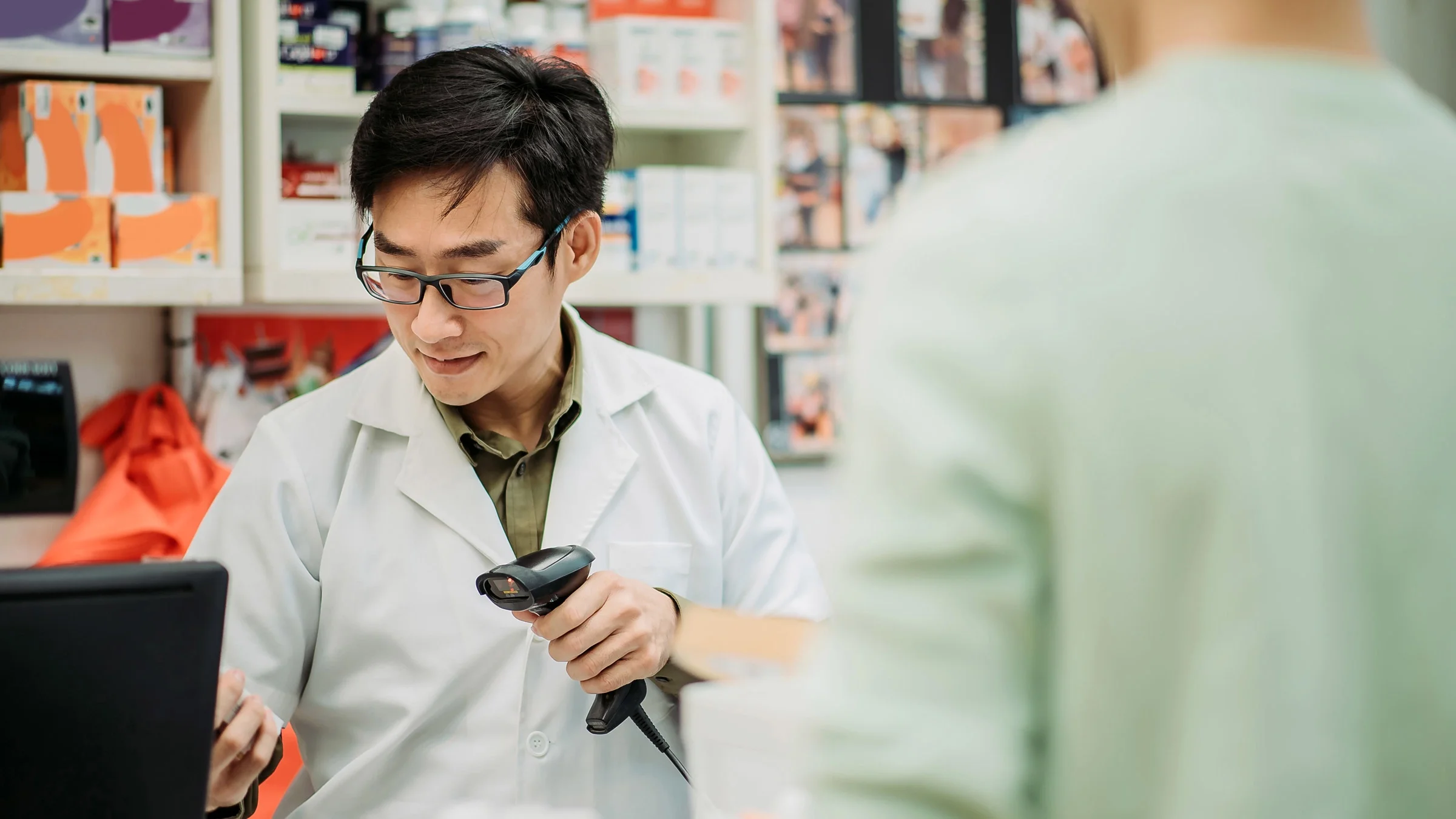 A pharmacist scanning the barcode on a pill bottle.