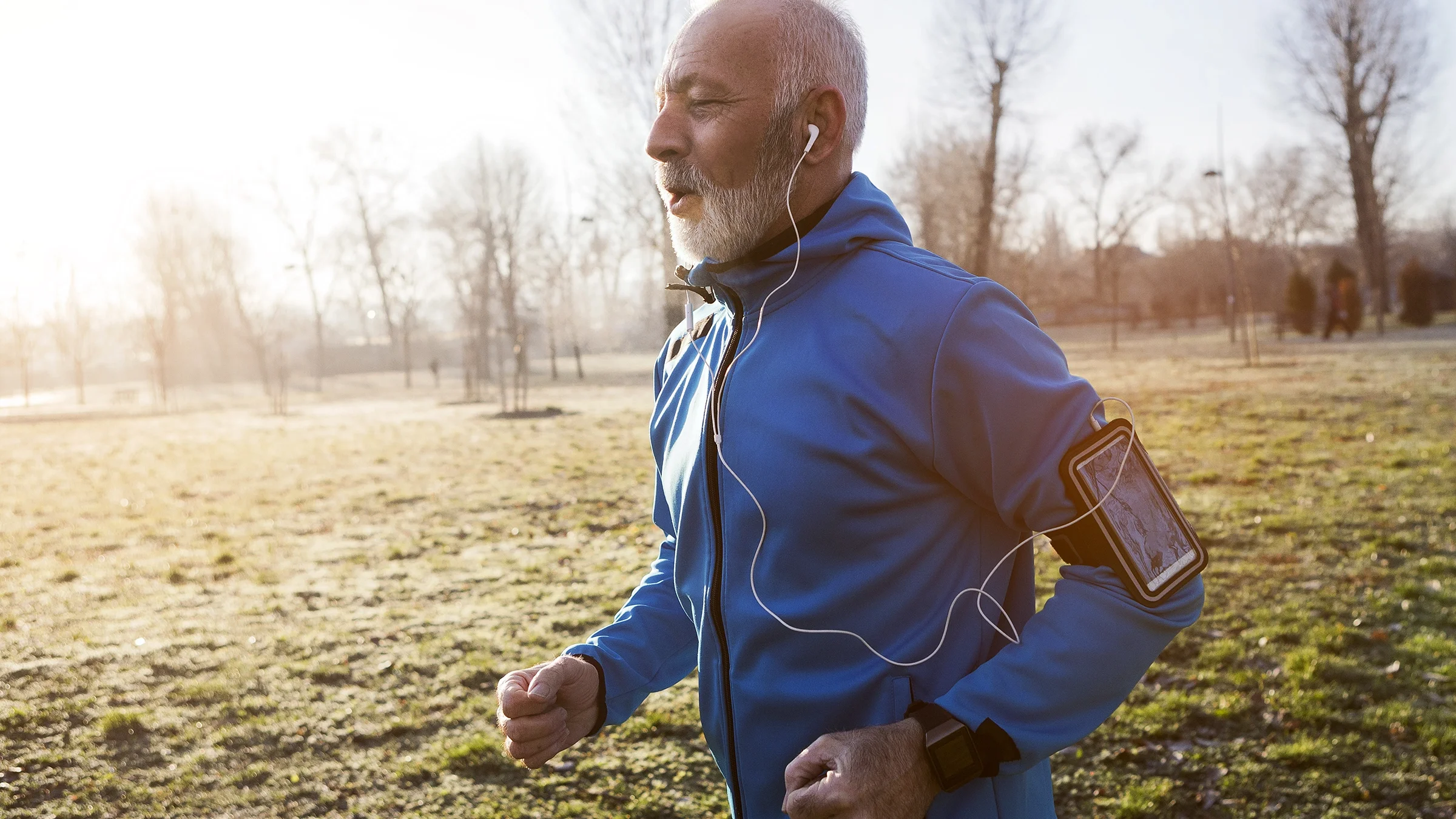 A senior man is shown jogging outside.