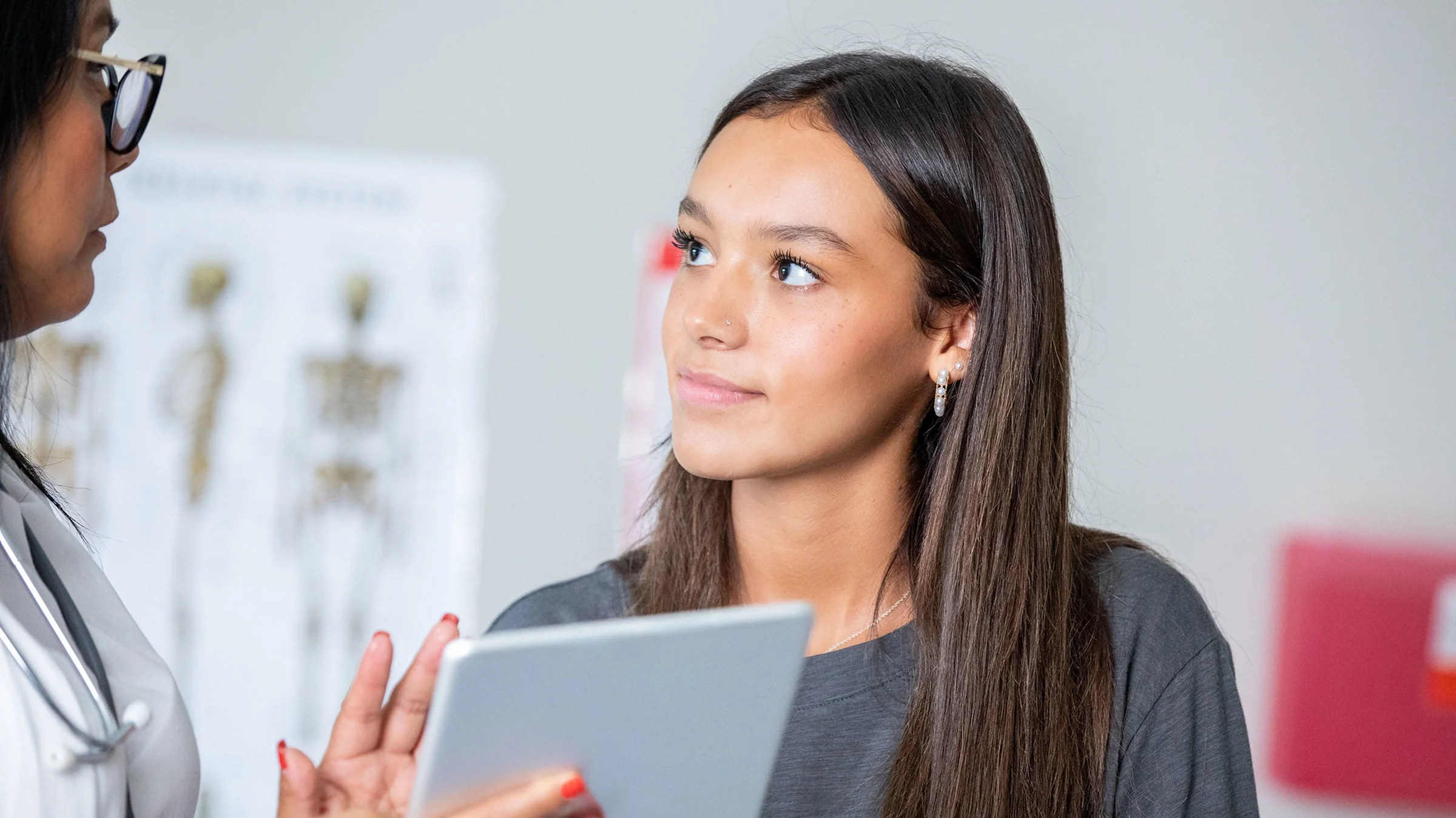 A teenage patient consults with a doctor.