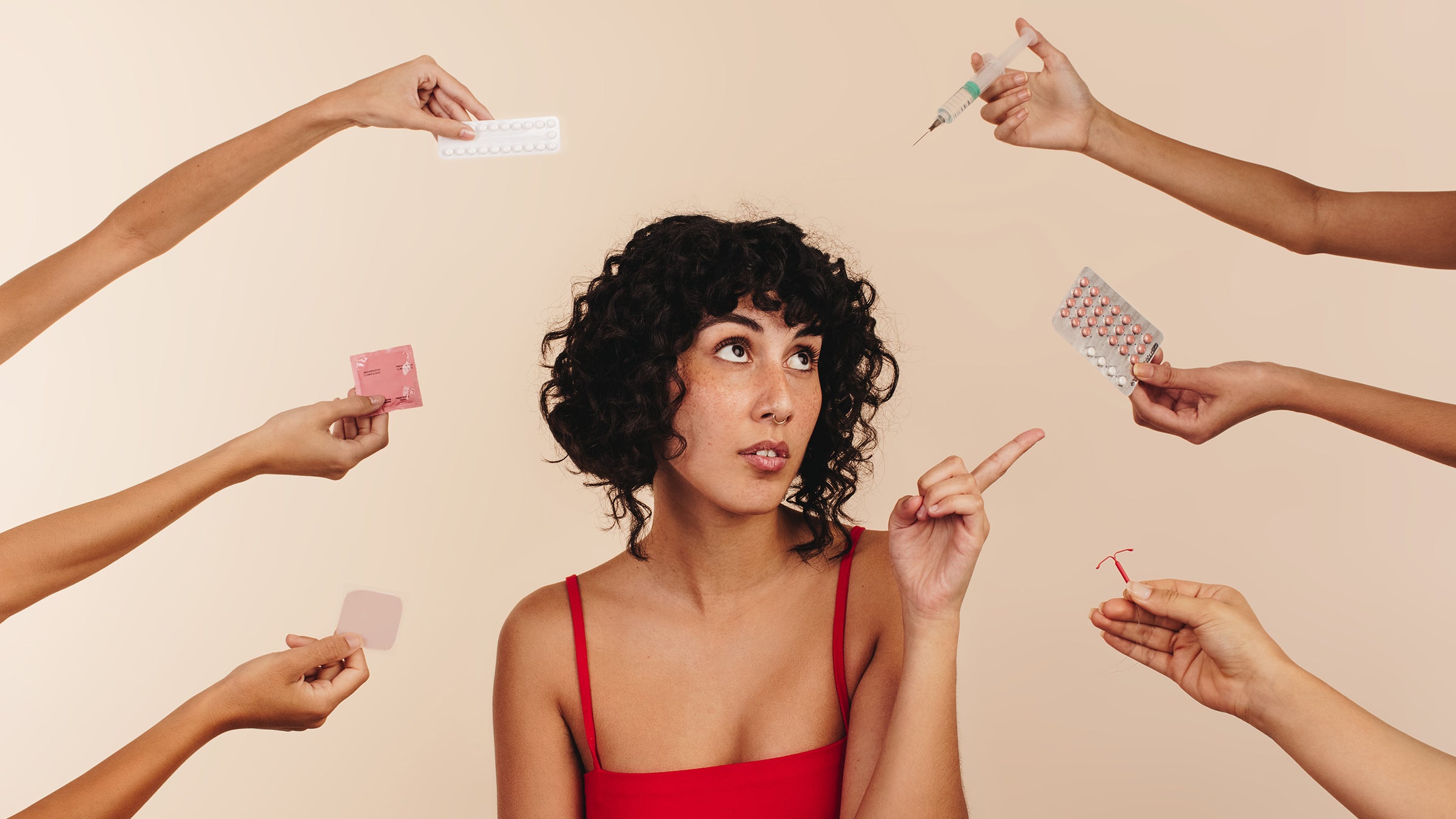 Reproductive: Women's Health: woman surrounded hands holding different contraceptives 1387667960