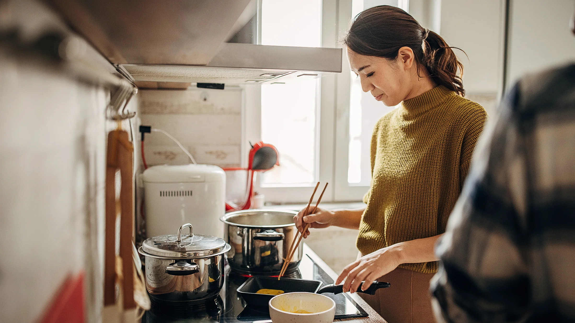 Woman cooking eggs at home.