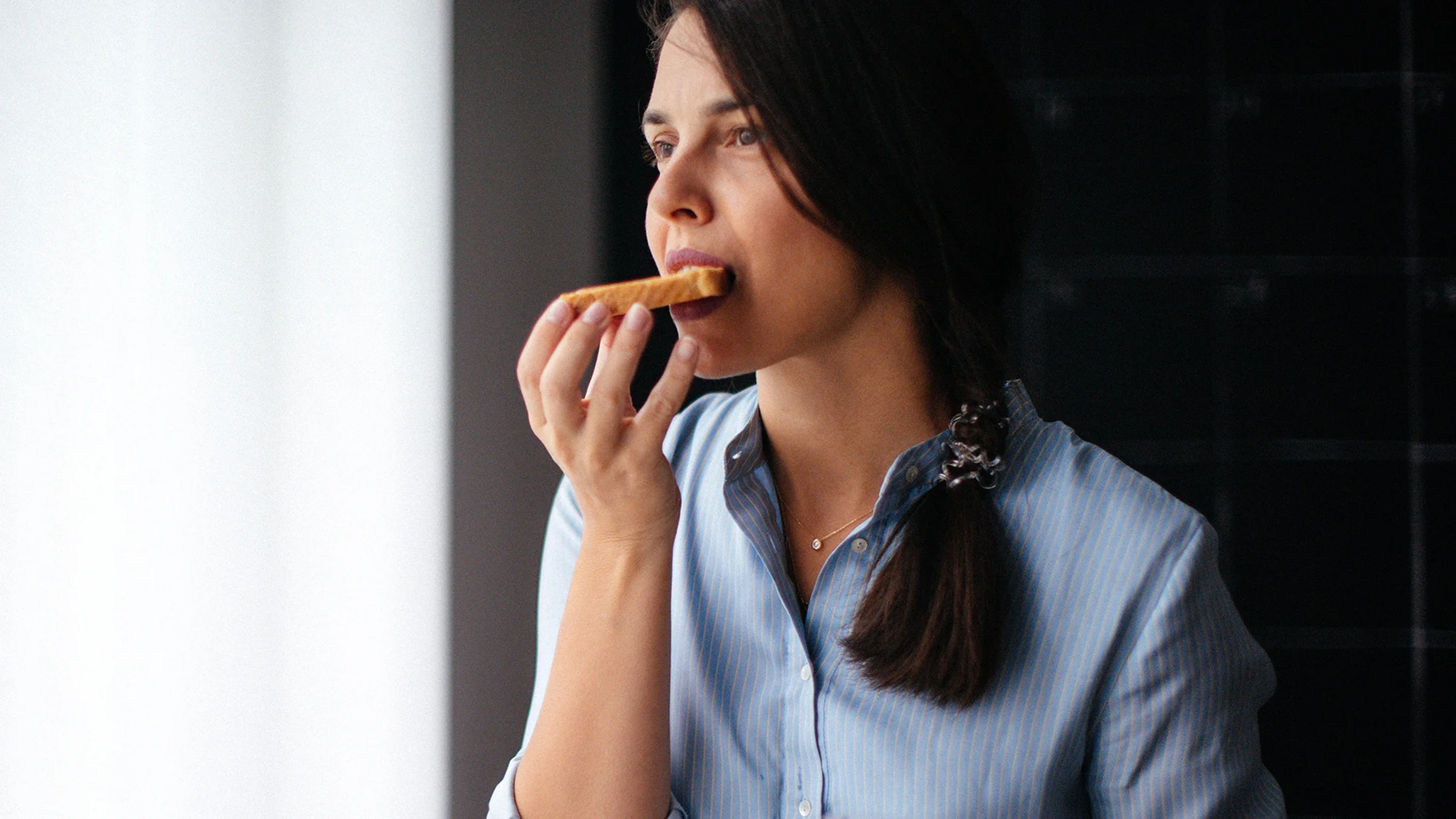 A woman eats a piece of toast.
StefaNikolic/E+ via Getty Images