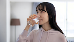 A woman takes medication with water.
Satoshi-K/E+ via Getty Images