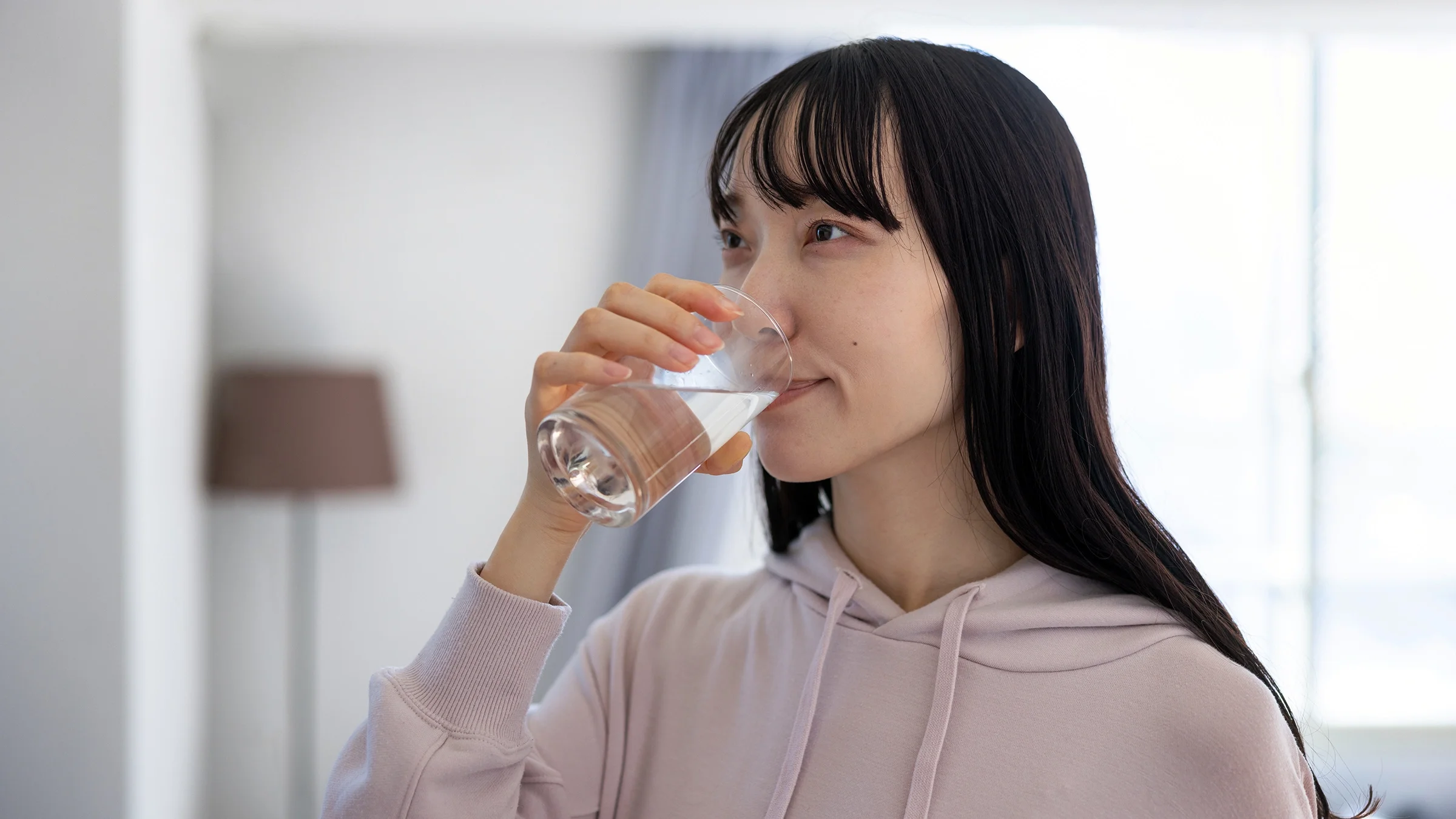A woman takes medication with water.