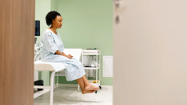 Herpes: woman sitting on exam table 2135684119