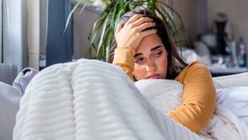 Long COVID: headache under blanket-1182815791