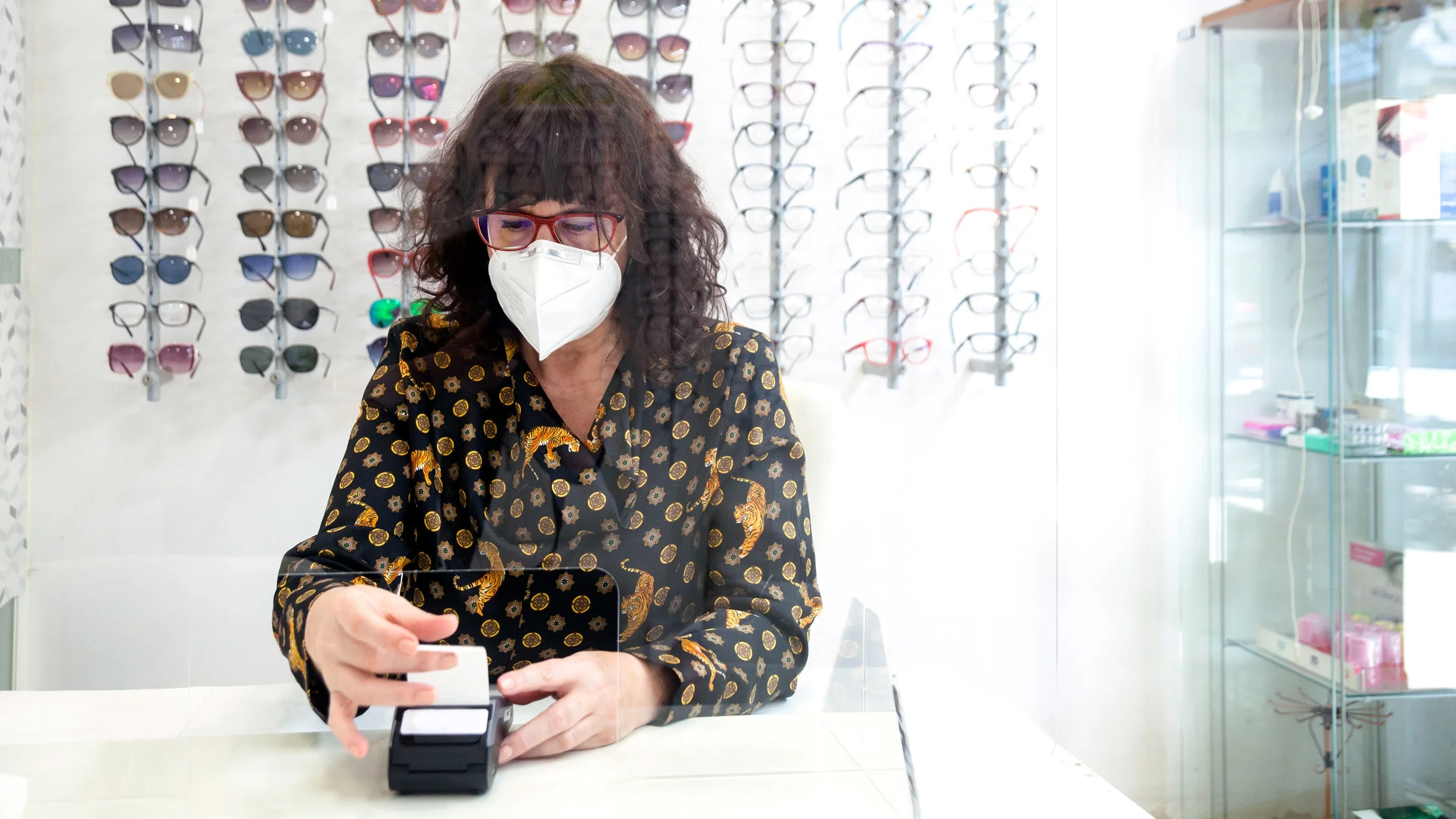 A customer making a credit card payment at an optical shop. 